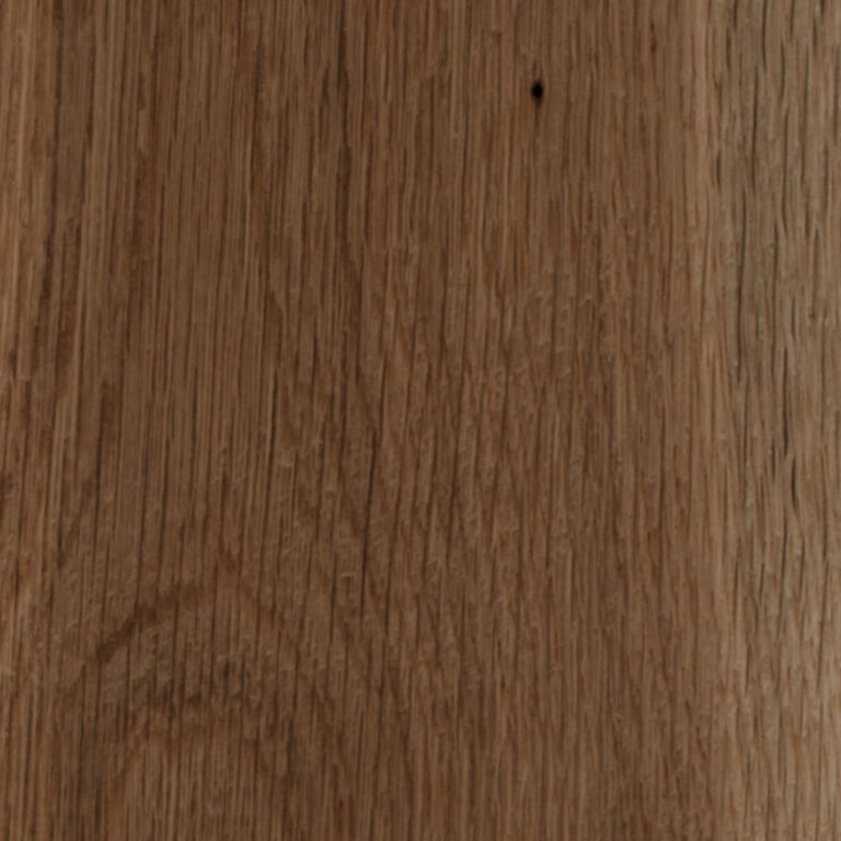 Close-up of a brown wooden surface showing tight vertical grain, a small dark knot near the top center, and a faint semicircular mark toward the lower left.