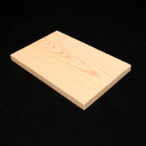 Cypress 1x10, Cypress 1x8, Cypress 1x6. Rectangular light-colored wooden board with visible grain lying flat on a black fabric background.