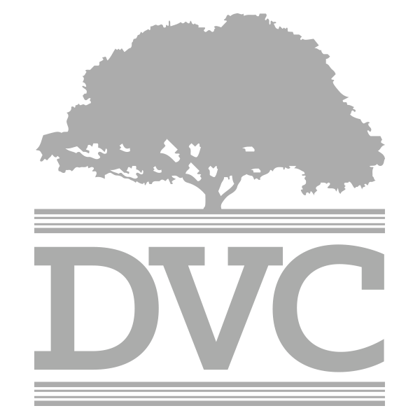 Gray logo featuring a broad, leafy tree silhouette above three thin horizontal lines, with large block letters DVC beneath and three thin horizontal lines below.