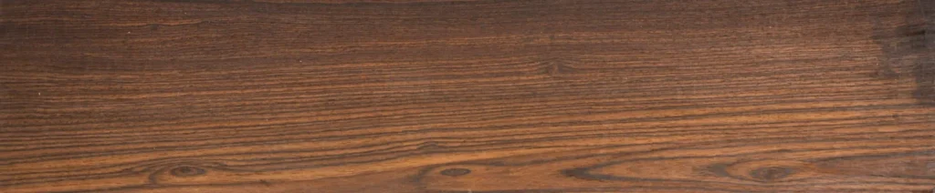 Rectangular dark brown wooden plank with vertical grain patterns and a few knots, shown full-length as a flooring or veneer sample.